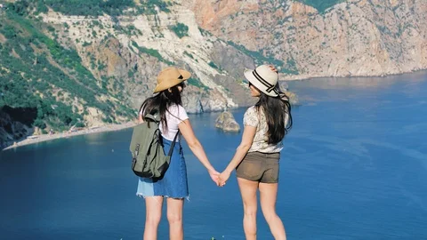 Back view two active female tourists smiling enjoying view of sea and mountain Stock-Footage 93214973