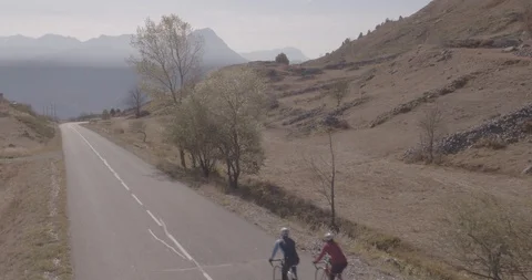 Back view of two cyclist riding uphill in pace Stock Footage 108721384