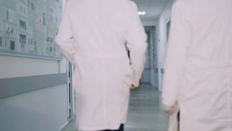 Back view of two doctors walking on hospital's corridor and advising Stock Footage 85992609