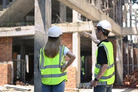 Back view of two engineer discussing new plan at construction site Foto stock