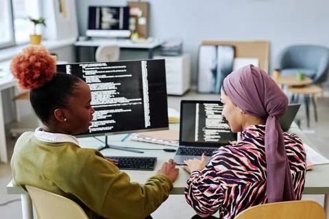 Back view at two female programmers writing code together Foto stock