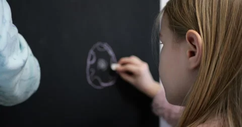 Back View of Two Girls Drawing Easter Bunny on Chalkboard Stock Footage 297699846