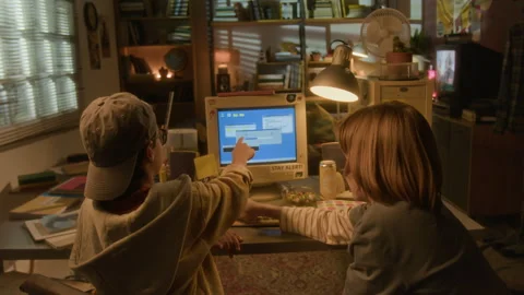 Back View of Two Kids using Computer in 90s Room Stock Footage 304864212