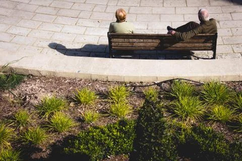 Back view of two people sitting on bench Stock Photos
