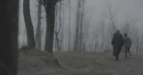 Back view of two people walking on a dirt path in a foggy landscape 스톡 동영상 327596098