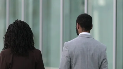 Back view of two people wearing suits walking near office building Stock Footage 114962057