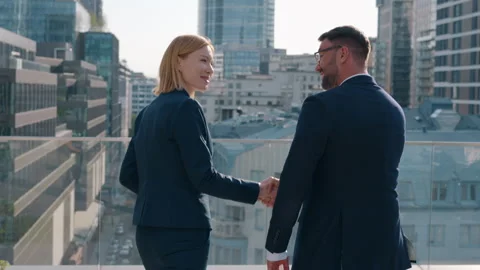 Back view two successful business partners male female handshaking outdoors Stock Footage 249106555