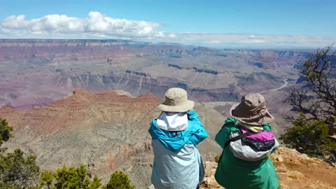 Back view two tourists womans hiking, taking smartphone photo of  Grand Canyon Stock Footage 111506445
