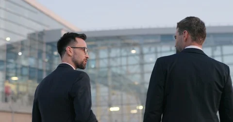 Back view on two young Caucasian handsome businessmen walking outdoor and Stock Footage 125231887
