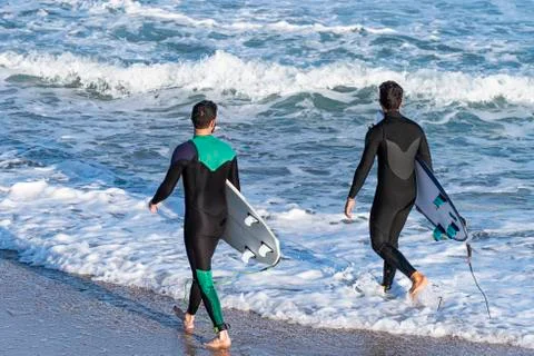 Back view of two young men with surfboards Stock Photos
