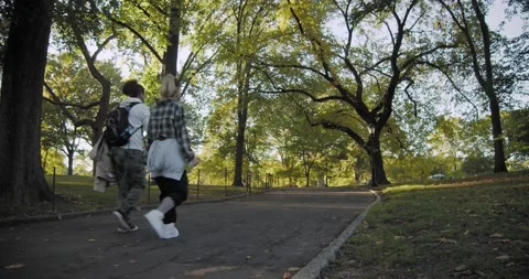 Back View of Two Young people walking along a path at Central Park New York 動画素材 219565954