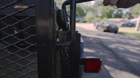 Back view of unlocking the safety pin on the trailer. Video stock 277626257