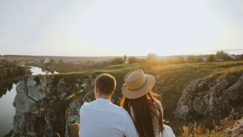 Back view of unrecognizable couple watching sunset on the cliff. Stock Footage 122559903