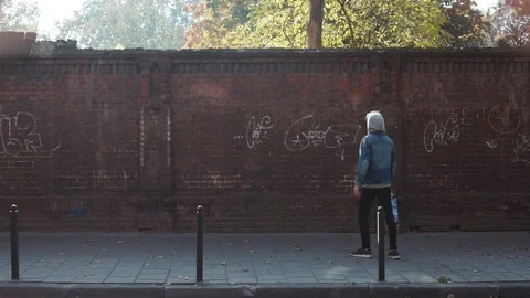 Back view of unrecognizable graffiti artist in a hood at working process Stock Footage 105243905