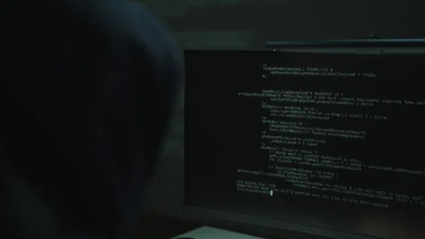 Back view of unrecognizable hooded hacker typing malicious code on computer Stock Footage 327474933