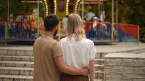 Back view of unrecognizable loving young couple watching rotation of attractions Stock Footage 227322066