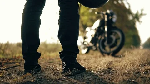 Back view of an unrecognizable man in black jeans and leather jacket holding his 스톡 동영상 82643613