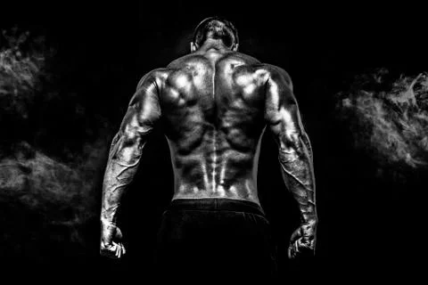 Back view of Unrecognizable man, strong muscles posing with arm up in smoke Stock Photos