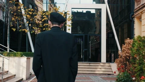 Back view of unrecognizable man walks along the city center street looks around Stock Footage 143356708