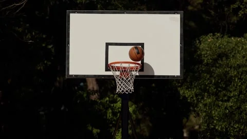 Back view of unrecognizable player throwing ball in a basketball hoop, the ball Stock Footage 236690921
