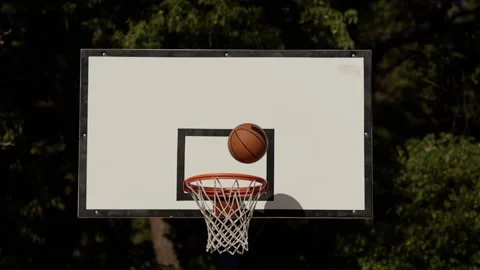 Back view of unrecognizable player throwing ball in a basketball hoop, the ball Stock Footage 240053965