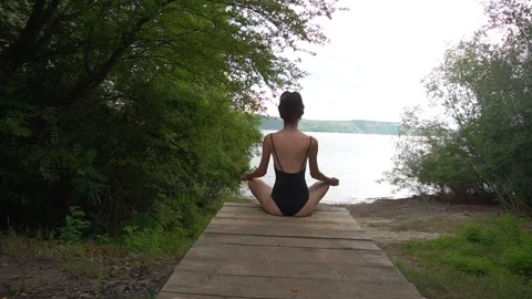 Back view of unrecognizable slender young woman sitting on yoga mat in lotus Stock Footage 250963992