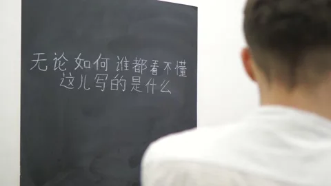 Back view of unrecognizable young man learning Chinese language in classroom Stock Footage 235559084