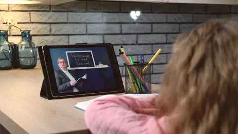 Back view video of a small girl listening to the teacher online on tablet Stock Footage 147478622