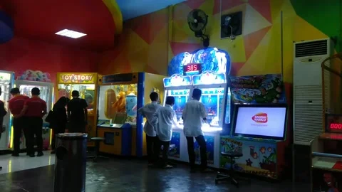 Back view of visitor play token slot machines in Arcade games center Stock Footage 222943644