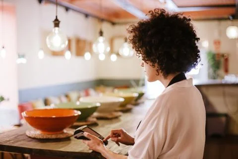 Back view of waitress working with a card terminal Stock Photos