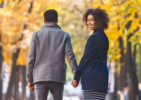 Back view of walking afro couple over autumn park Fotos Stock
