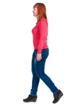 Back view of walking cheerful redhead woman in jeans Stock-Fotos
