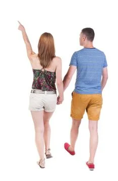 Back view of walking young couple (man and woman) pointing Stock Photos