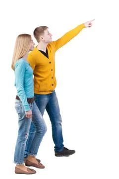 Back view of walking young couple (man and woman) pointing Stock-Fotos