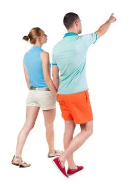 Back view of walking young couple (man and woman) pointing Stock Photos
