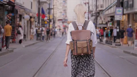 Back view of walking young female traveler backpack in city on city street 動画素材 252895163