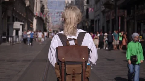 Back view of walking young female traveler backpack in city on city street Stock Footage 252895198