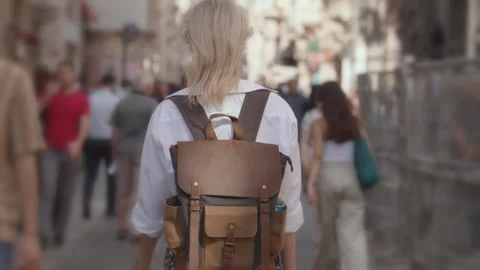 Back view of walking young female traveler backpack in city on city street 스톡 동영상 252917867