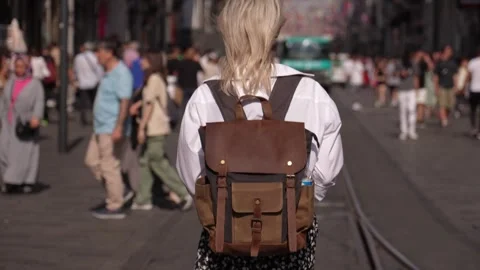 Back view of walking young female traveler backpack in city on city street Stock Footage 252919701
