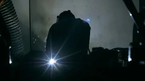 Back view welder man working using welding machine flashing bright sparks Stock Footage 153980917