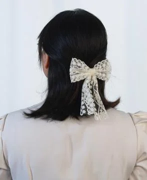 Back view of white lace bow hair clip, elegant styling accessory Stock Photos
