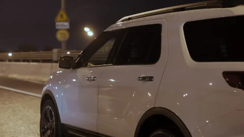 Back view of white tinted SUV car driving on wet asphalt road in the rain Stock Footage 196290350