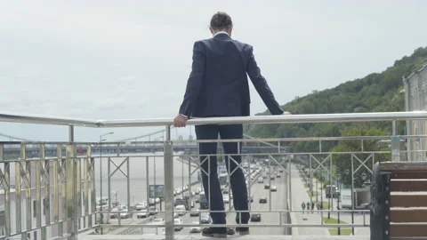 Back view wide shot of suicidal man attempting to commit suicide standing at Stock Footage 140274324