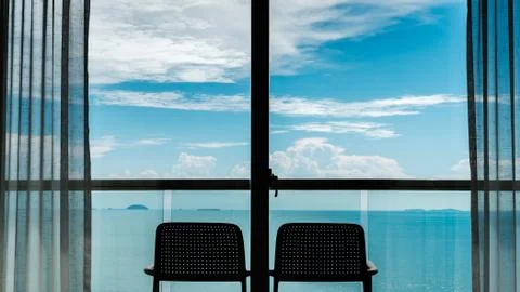 Back view from the window of 2 chairs on the balcony, sea and sky views. Stock Photos
