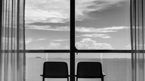 Back view from the window of 2 chairs on the balcony, sea and sky views in bl Foto stock