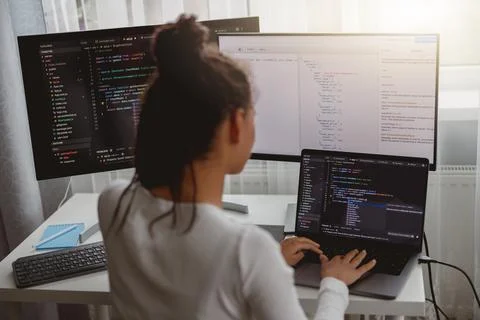 Back view of woman coding on computer, professional female programmer working in Stock Photos