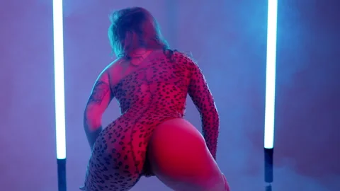 Back view of woman dancing, shaking, twerking buttocks on neon background. Vidéo 243655891