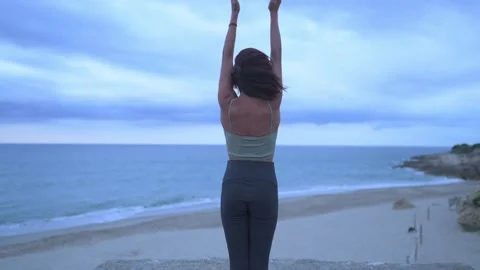 Back view of woman doing the sun salutation during a yoga session. Stock Footage 219565277