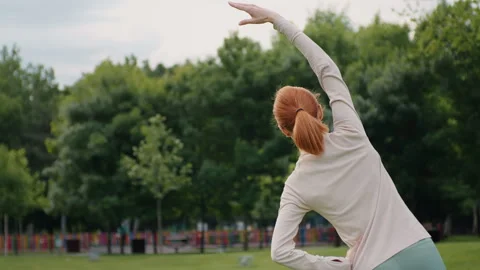 Back view of woman doing torso, arms, legs strech outdoor. Stock Footage 295779596