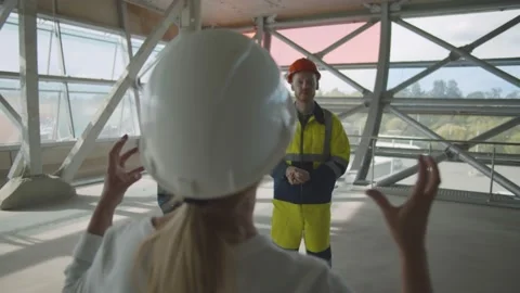 Back view of woman engineer at building site instruction construction workers Stock Footage 137319807